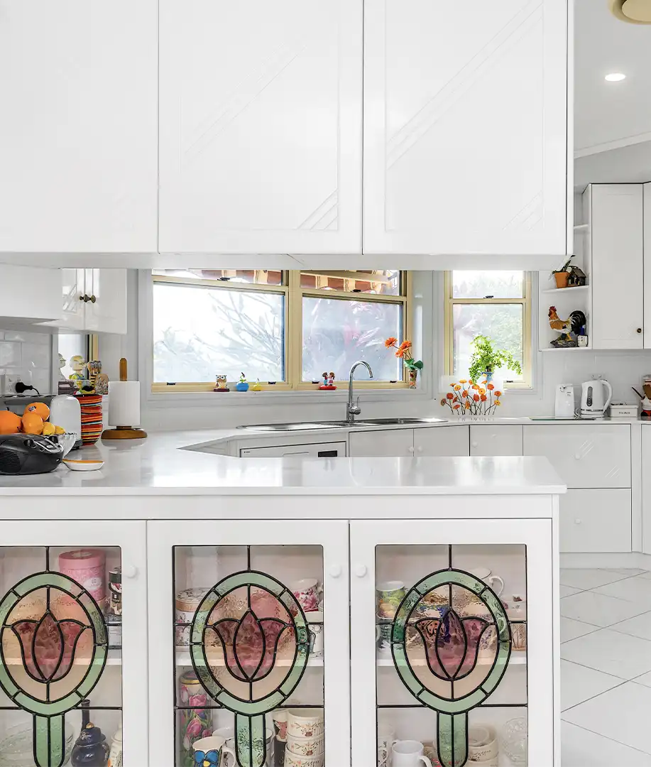a timeless white elegant kitchen designed and installed by glenlyon kitchens showing the stained glass cabinetry
